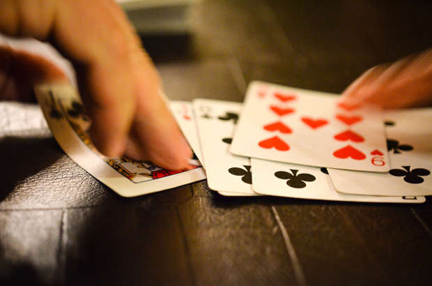 Dealer dealing cards from a poker deck.